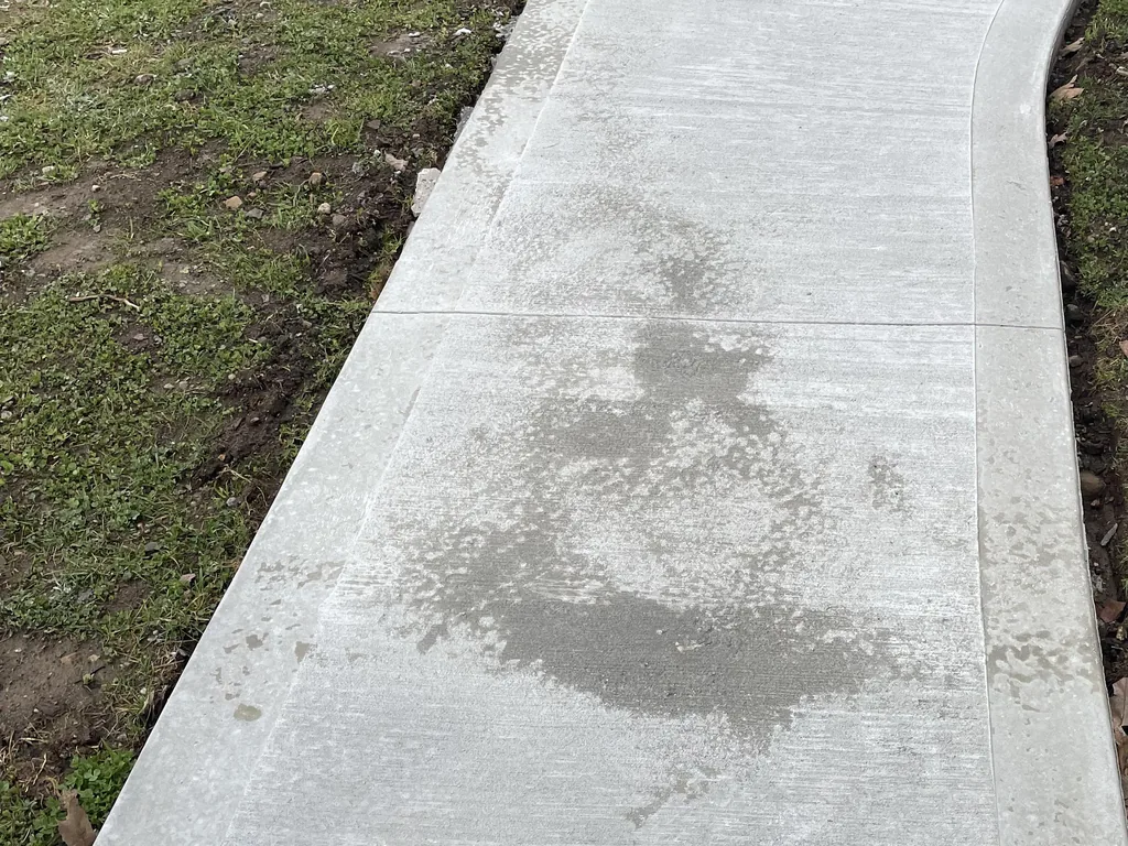 New curved concrete front walk with a broom finish running through the lawn, concrete patios and walkways